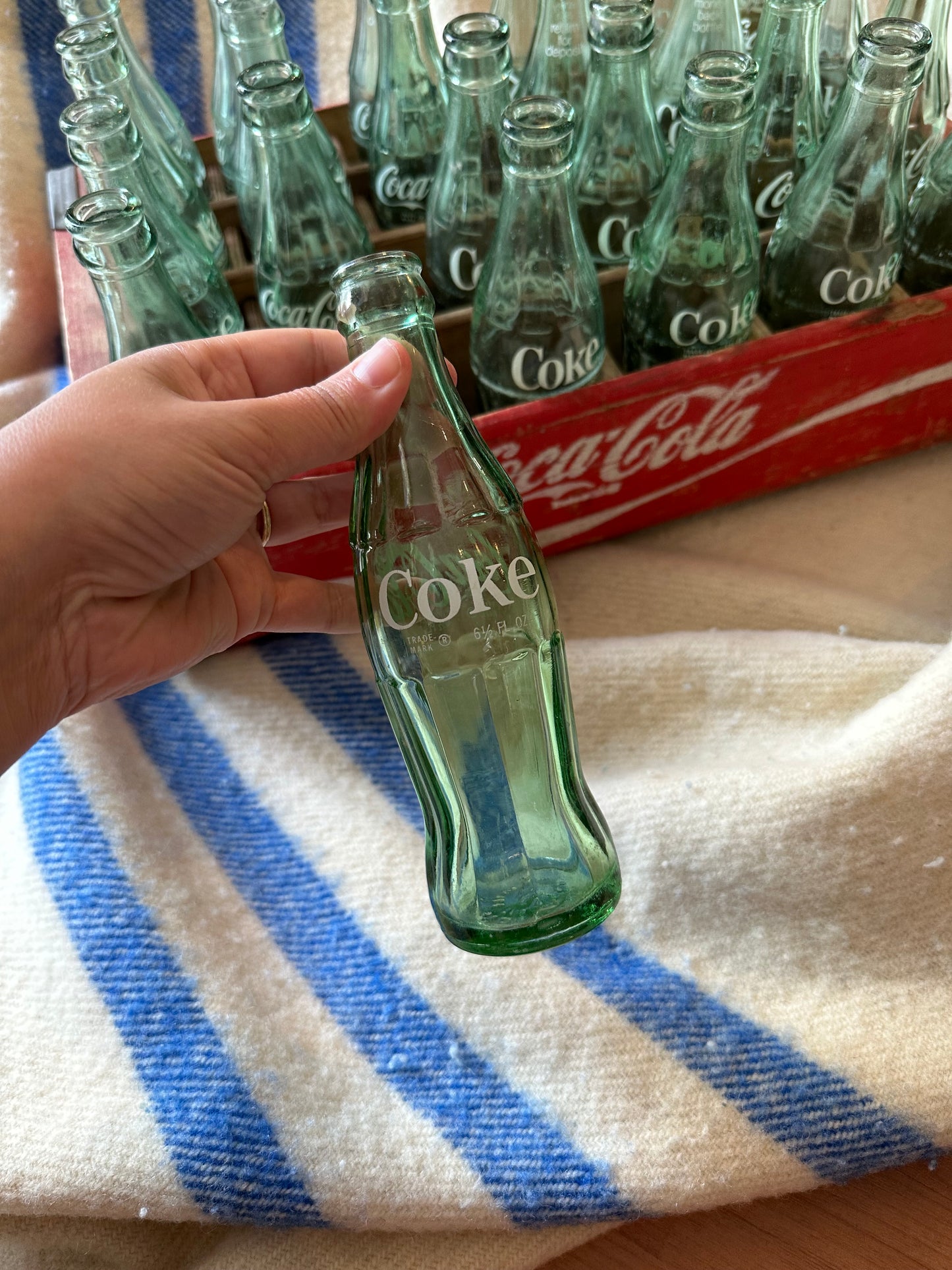 Coca Cola crate with 24 vintage Coca Cola bottles all manufactured in a different place