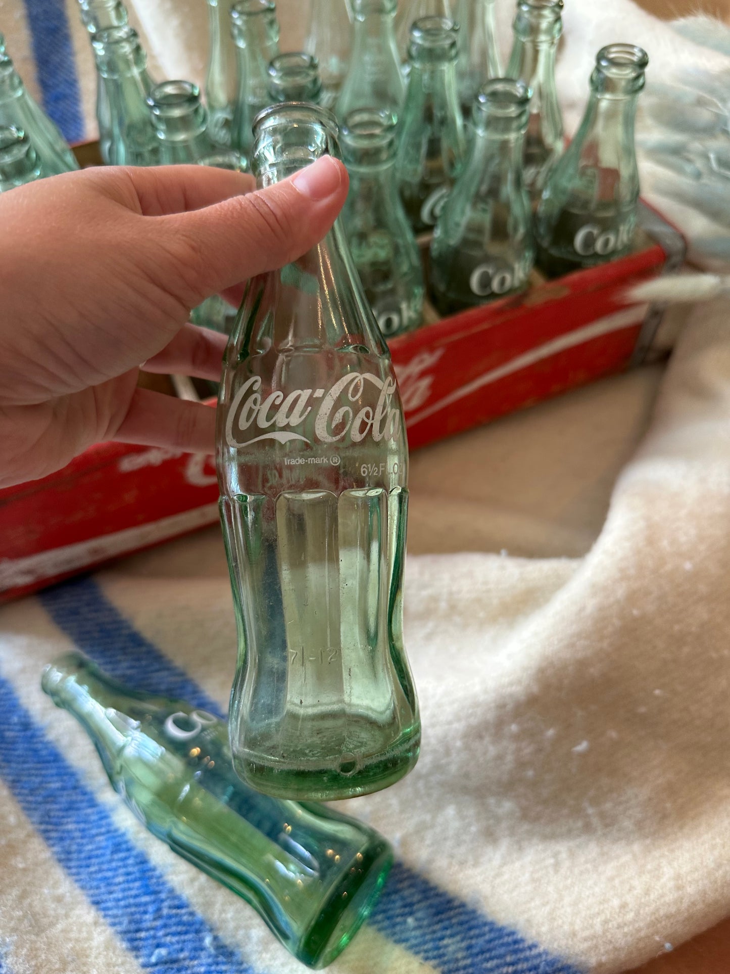 Coca Cola crate with 24 vintage Coca Cola bottles all manufactured in a different place