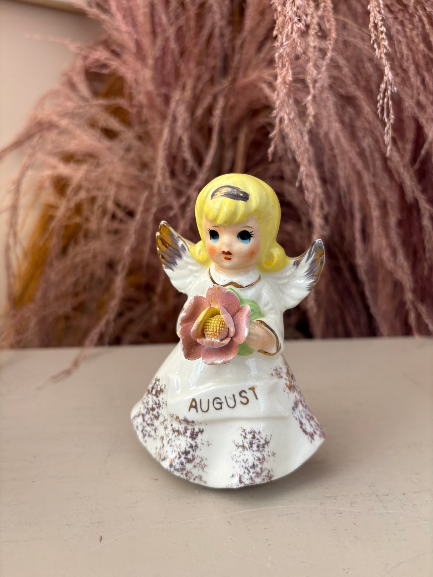 August Angel Figure holding pink flower