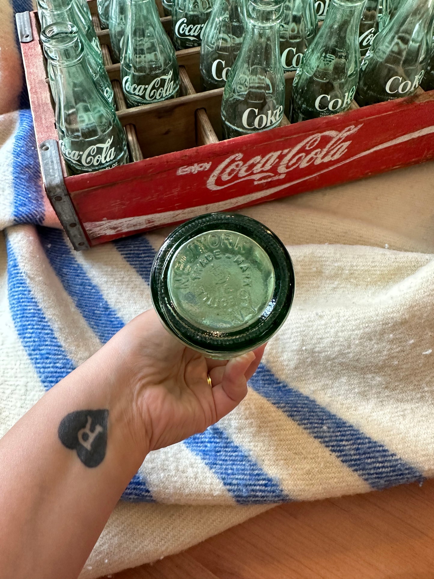 Coca Cola crate with 24 vintage Coca Cola bottles all manufactured in a different place