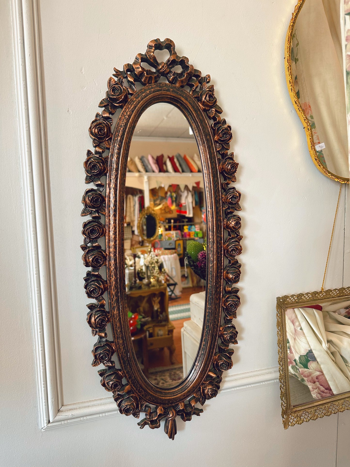 Oval mirror with floral details on frame